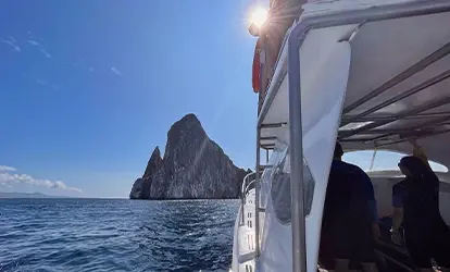 People in a yacht arriving at the Kicker Rock.